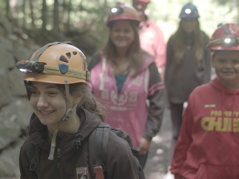 Guide-Leading-Group-into-the-Adventure-Mine-Smiling